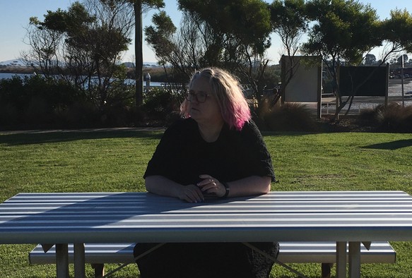 Person sitting at a picnic table without painting materials