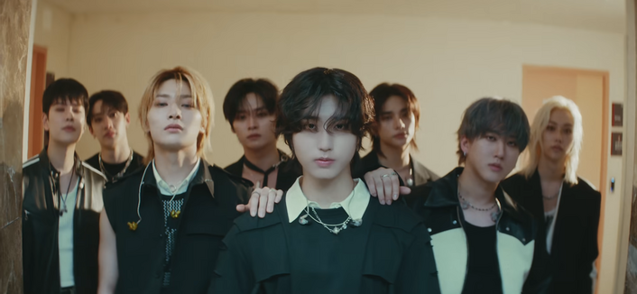 Cutie Han Jisungie looks piercingly into the camera while the other members stand behind him